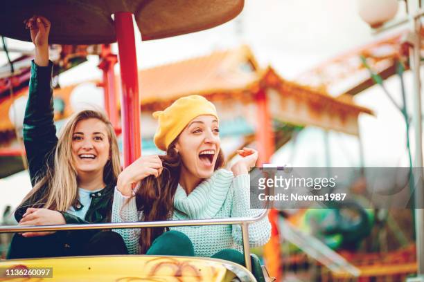 wir werden spaß am vergnügungspark haben - young woman screaming on a rollercoaster stock-fotos und bilder