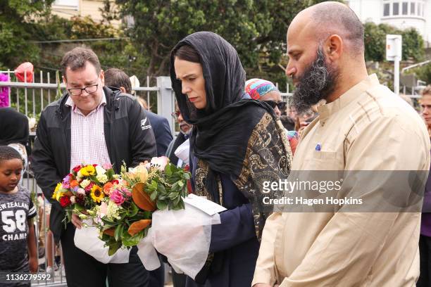 Prime Minister Jacinda Ardern lays flowers while finance minister Grant Robertson looks on at the Kilbirnie Mosque on March 17, 2019 in Wellington,...