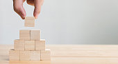 Hand arranging wood block stacking as step stair. Business concept for growth success process
