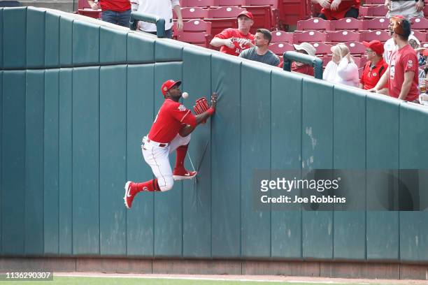 Yasiel Puig of the Cincinnati Reds tries to catch the ball against the right field wall in foul territory in the first inning against the Miami...