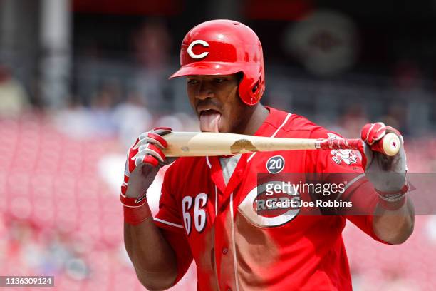 Yasiel Puig of the Cincinnati Reds licks his bat after fouling off a pitch in the seventh inning against the Miami Marlins at Great American Ball...