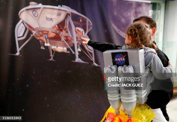 An Israeli boy plays with a model of the Israeli spacecraft Beresheet's, at the Planetaya Planetarium in the Israeli city of Netanya, on April 11,...