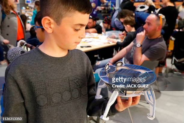 An Israeli boy plays with a model of Israeli spacecraft, Beresheet's, at the Planetaya Planetarium in the Israeli city of Netanya, on April 11, 2019...