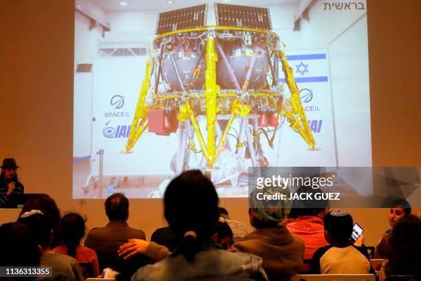People watch a screen showing explanations of the landing of Israeli spacecraft, Beresheet's, at the Planetaya Planetarium in the Israeli city of...