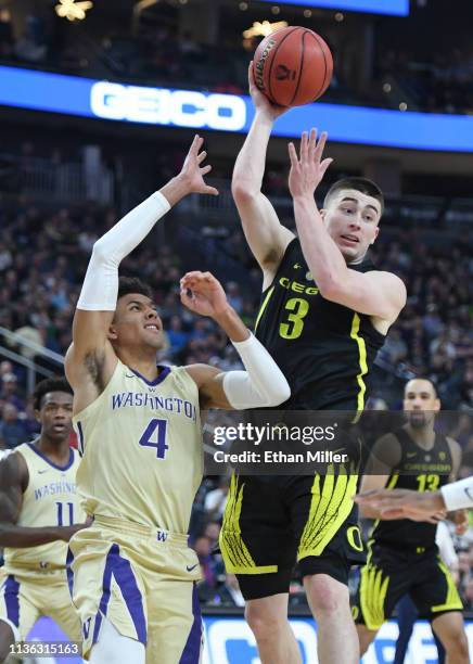 Payton Pritchard of the Oregon Ducks passes under pressure from Matisse Thybulle of the Washington Huskies during the championship game of the Pac-12...