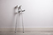 Two Crutches Leaning Against Concrete Wall