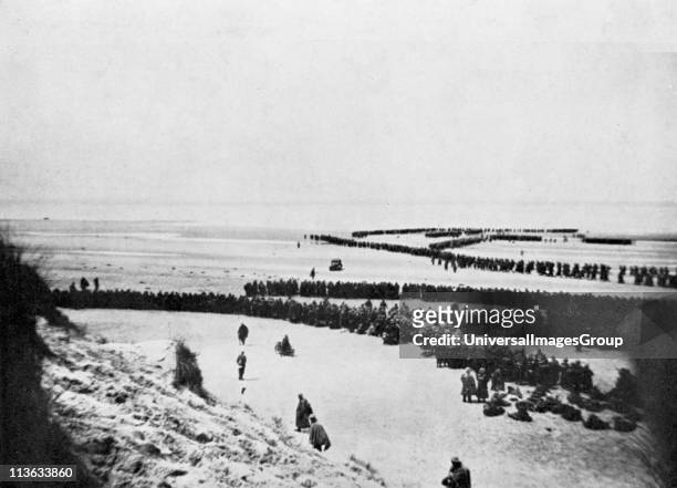 World War 2: British retreat from Dunkirk. British troops forming into winding queues waiting to board small boats which ferried them to larger...