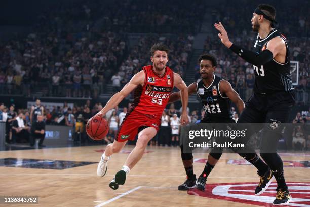 Damian Martin of the Wildcats drives into the keyway against Casper Ware and Josh Boone of United during game 4 of the NBL Grand Final Series between...