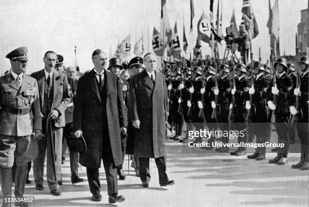 British Prime Minister Neville Chamberlain passes a Nazi honour guard on his arrival at Oberwiesenfeld airport before a meeting with Adolf Hitler...