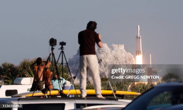 Visitors at Playalinda Beach look on as a SpaceX Falcon Heavy rocket launches from Pad 39B at the Kennedy Space Center in Florida, on April 11, 2019....