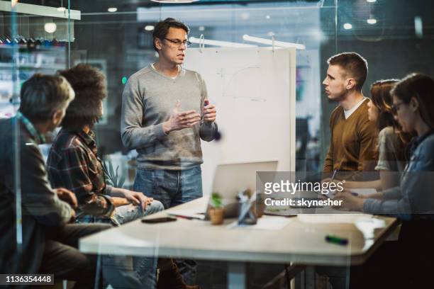 mid adult businessman talking to his colleagues on presentation in the office. - engineer stock pictures, royalty-free photos & images