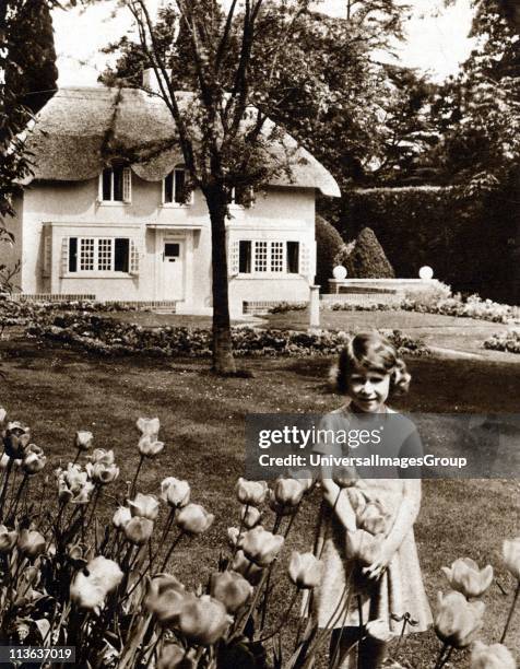 Princess Elizabeth as a child in the garden of Royal Lodge, Windsor with Y Bwthyn Bach the play house given by the people of Wales