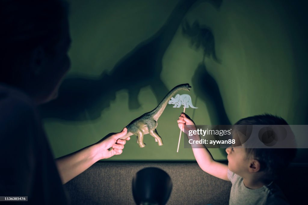Madre y adorable hijo jugando con las sombras