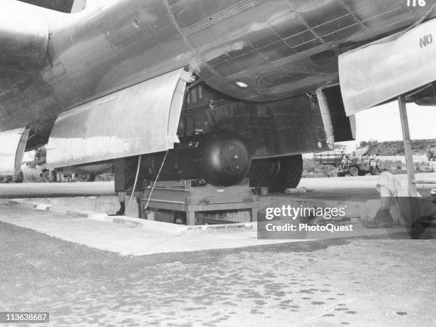 View of the atomic bomb, codenamed 'Little Boy,' as it is hoisted into the bomb bay of the B-29 Superfortress 'Enola Gay' on the North Field of...