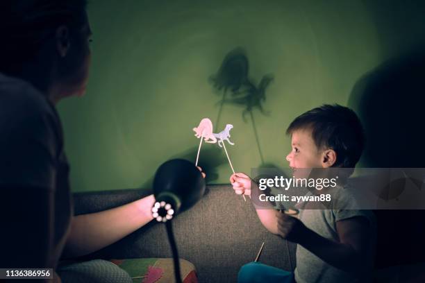 mother and cute son playing with shadows - shadow puppets stock pictures, royalty-free photos & images