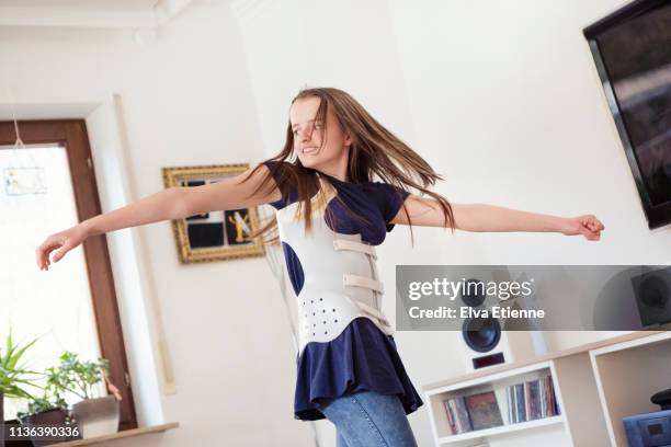 teenager spinning whilst wearing back brace worn for scoliosis correction - scoliosis stock pictures, royalty-free photos & images