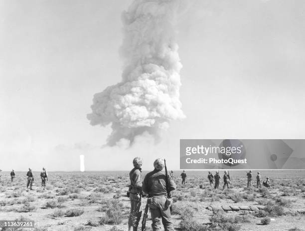 Military Private First Class Jack Wilson and Sergeant Glenn Poth look at the smoke plume of a nuclear detonation as part of Operation Tumbler-Snapper...