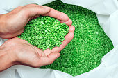 hands hold or touching biodegradable plastic pellets, plastic polymer granules