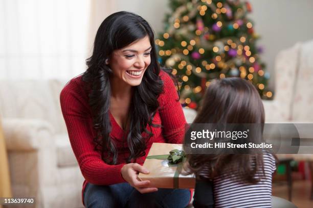 hispanische mutter gibt tochter weihnachten geschenk - child giving gift stock-fotos und bilder