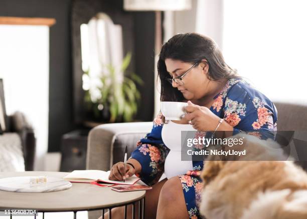 writing in her diary - morning tea stockfoto's en -beelden