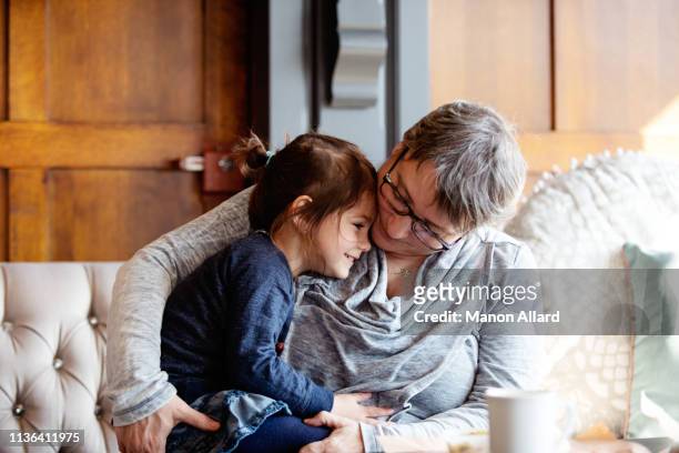 grandmother at coffee shop with her sweet granddaughter - granddaughter stock pictures, royalty-free photos & images