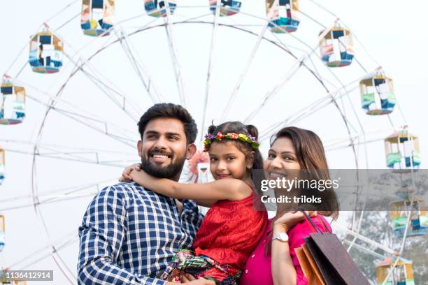 indian family posing in front of ferris wheel - annual love ride stock pictures, royalty-free photos & images