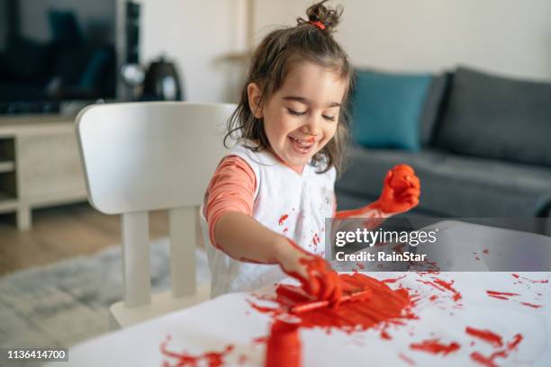 happy little child having fun doing finger painting at home - a child playing in a mess stock pictures, royalty-free photos & images