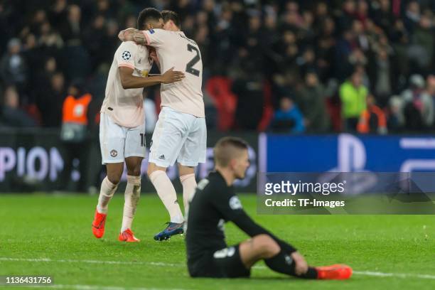 Marcus Rashford of Manchester United and Victor Lindeloef of Manchester United celebrate and Marco Verratti of Paris Saint-Germain sits on the ground...