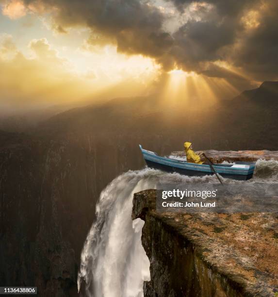 rowing towards catastrophic, dangerous waterfall - ignorance photos et images de collection