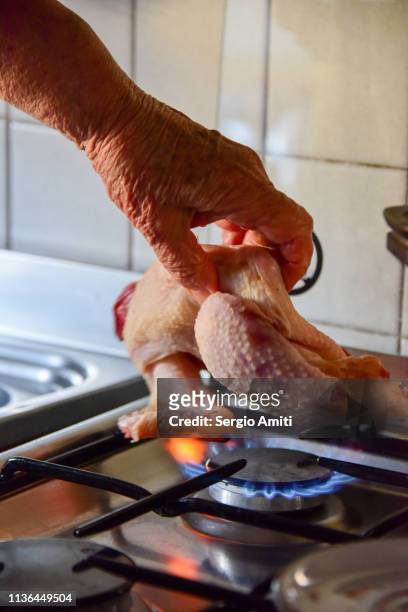 burning hairs off a raw chicken - burnt chicken stock pictures, royalty-free photos & images