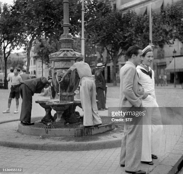 Men quench their thirst at a fountain in a street in Barcelona in April 1949.