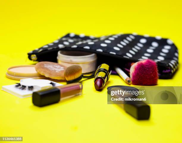 cosmetics and make up equipment on yellow background - make up bag fotografías e imágenes de stock