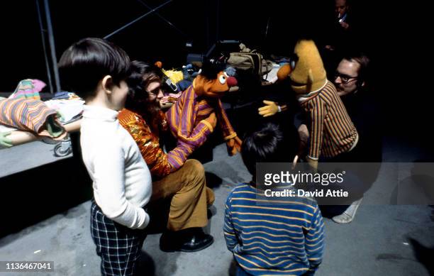 Puppeteer Jim Henson , holding Ernie, and puppeteer Frank Oz , holding Bert, entertain children during rehearsals for an episode of Sesame Street at...
