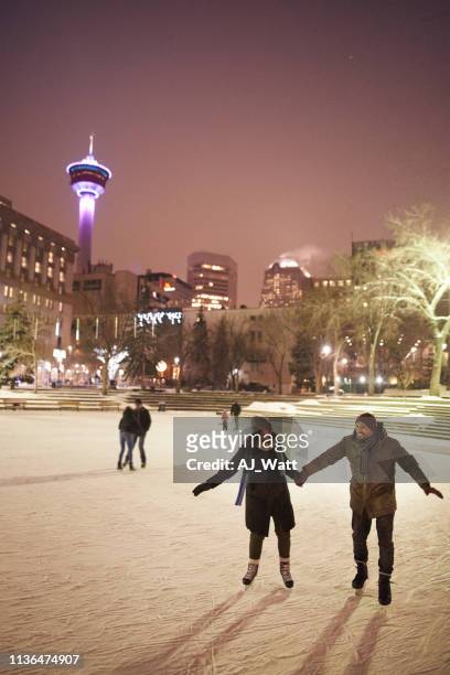 couple ice skating at rink - calgary skating stock pictures, royalty-free photos & images