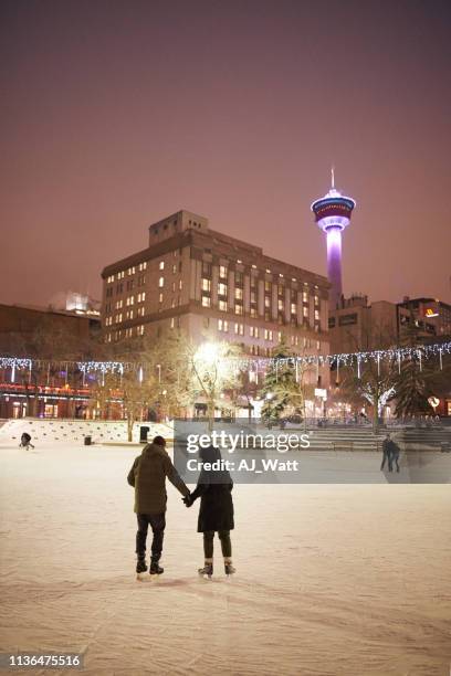 couple ice skating at rink - mid adult couple stock pictures, royalty-free photos & images