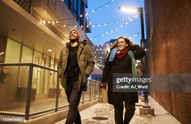 enjoying a winter evening in the city - woman snow outside night stockfoto's en -beelden