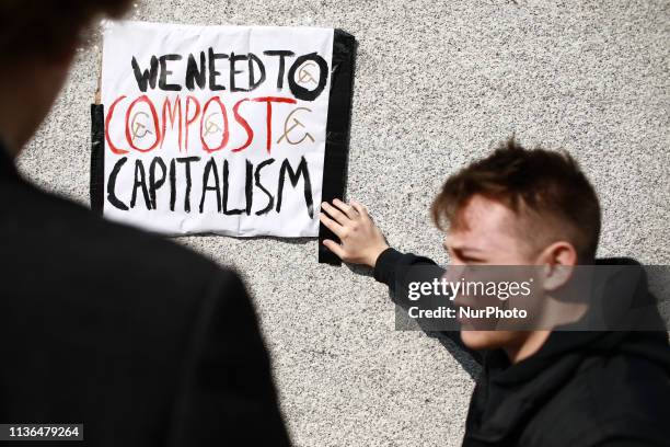 Members of the Marxist Student Federation fix an anti-capitalist sign to the base of the statue of Winston Churchill in Parliament Square ahead of...