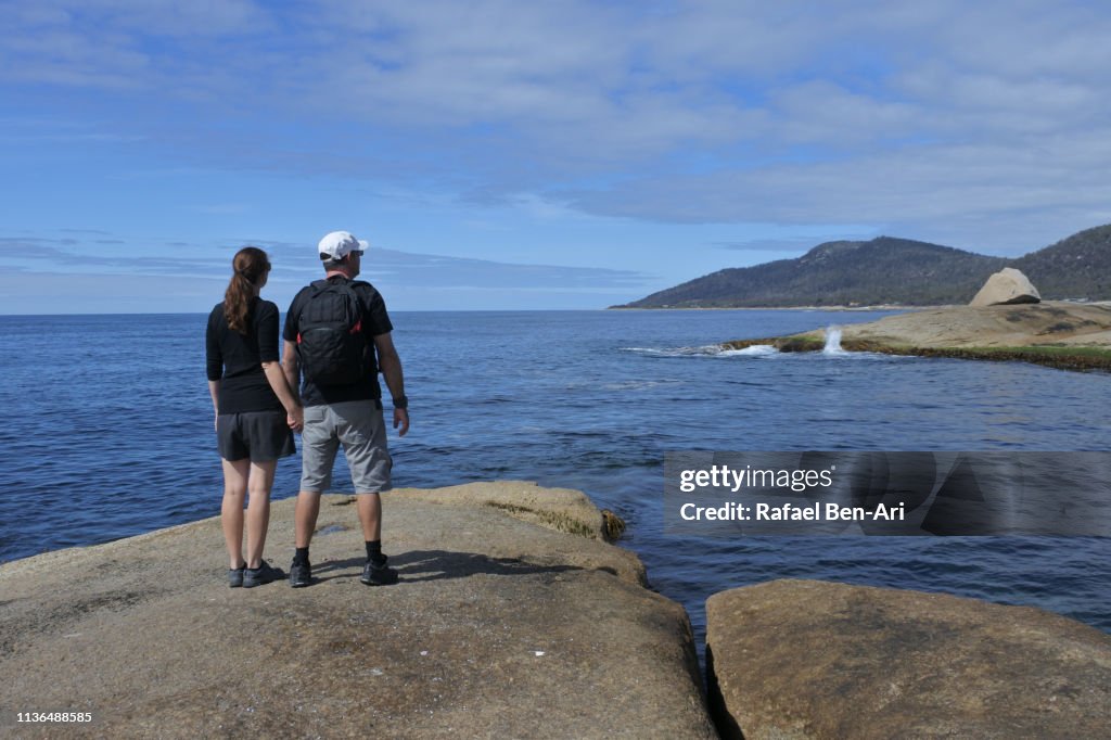 Tourist couple visit at the  Bay of Fires in Tasmania Australia