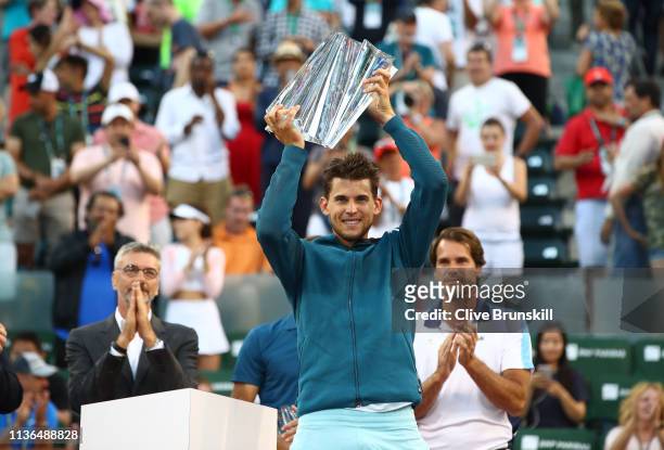 Dominic Thiem of Austria holds the championship trophy aloft after his men's singles final victory against Roger Federer of Switzerland on day...