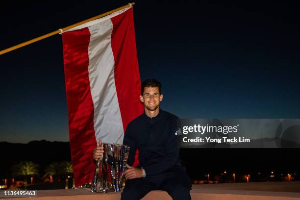 Dominic Thiem of Austria poses with the winner's trophy after defeating Roger Federer of Switzerland in the men's singles final on Day 14 of the BNP...