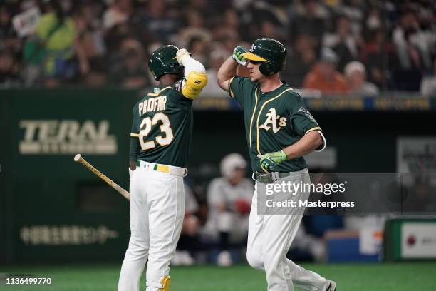 Outfielder Stephen Piscotty of the Oakland Athletics celebrates after hitting a solo homer with Infielder Jurickson Profar to make it 1-0 in the top...