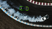 Two cars drifting battle on race track with smoke, Aerial view two car drifting battle.