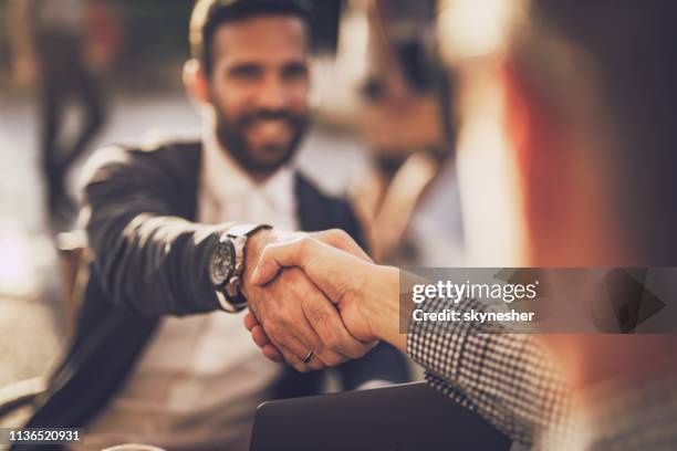 cerca de dos empresarios sacudiendo la mano en un café de la ciudad. - reliable fotografías e imágenes de stock