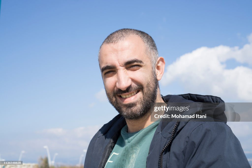 Middle Eastern man smiling outdoors