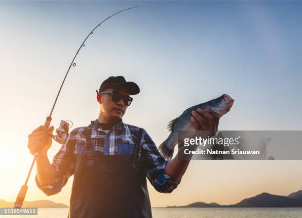 fisherman holding big fish. - freshwater fishing stock photos et images de collection