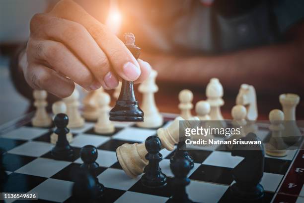 hand of businessman playing chess game. - scacchi foto e immagini stock