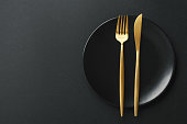 Gold cutlery set on black background