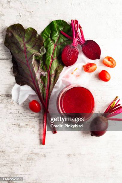 bieten sap en verse rode biet, detox veganistische smoothies van rauwe bieten en tomaat - antioxidant stockfoto's en -beelden