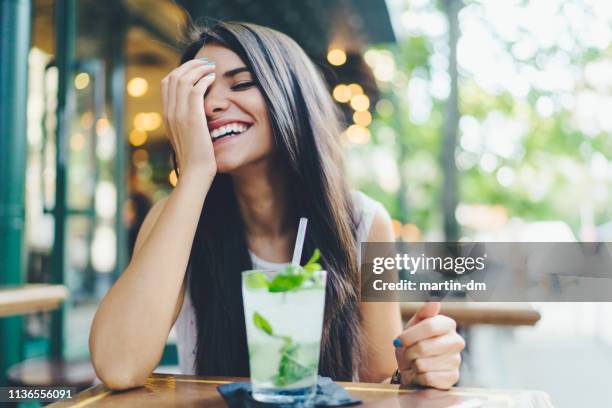 beautiful woman enjoying fresh mojito in bar - mint leaf restaurant stock pictures, royalty-free photos & images