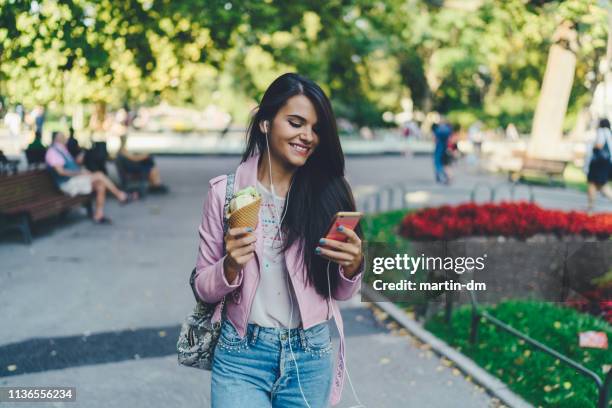 city girl eating ice-cream and texting - music city walk stock pictures, royalty-free photos & images